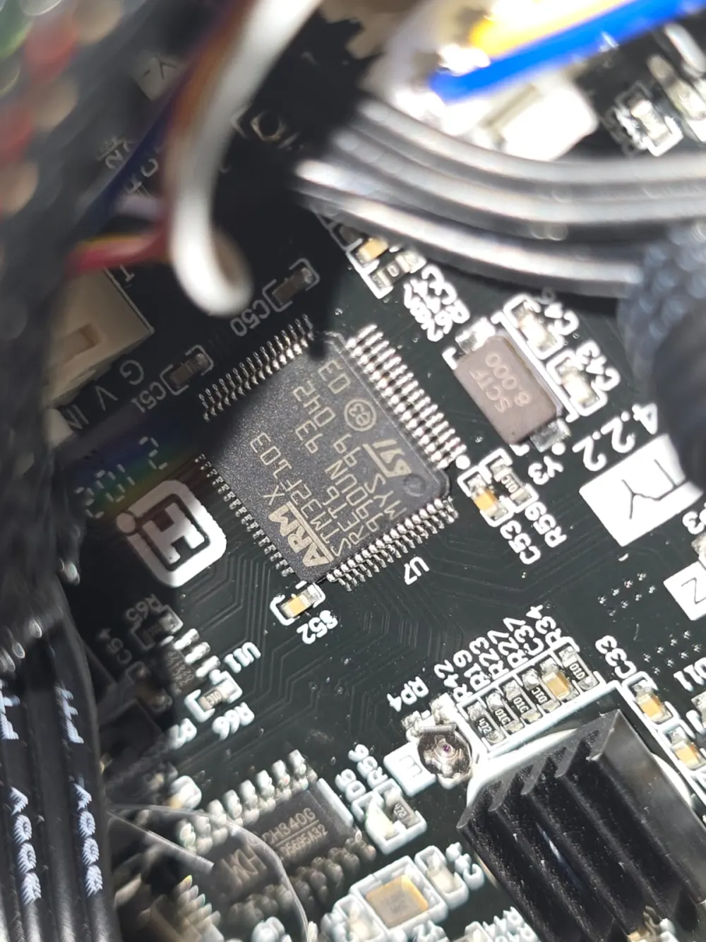 Close-up of an ARM microcontroller and surrounding components on a black circuit board